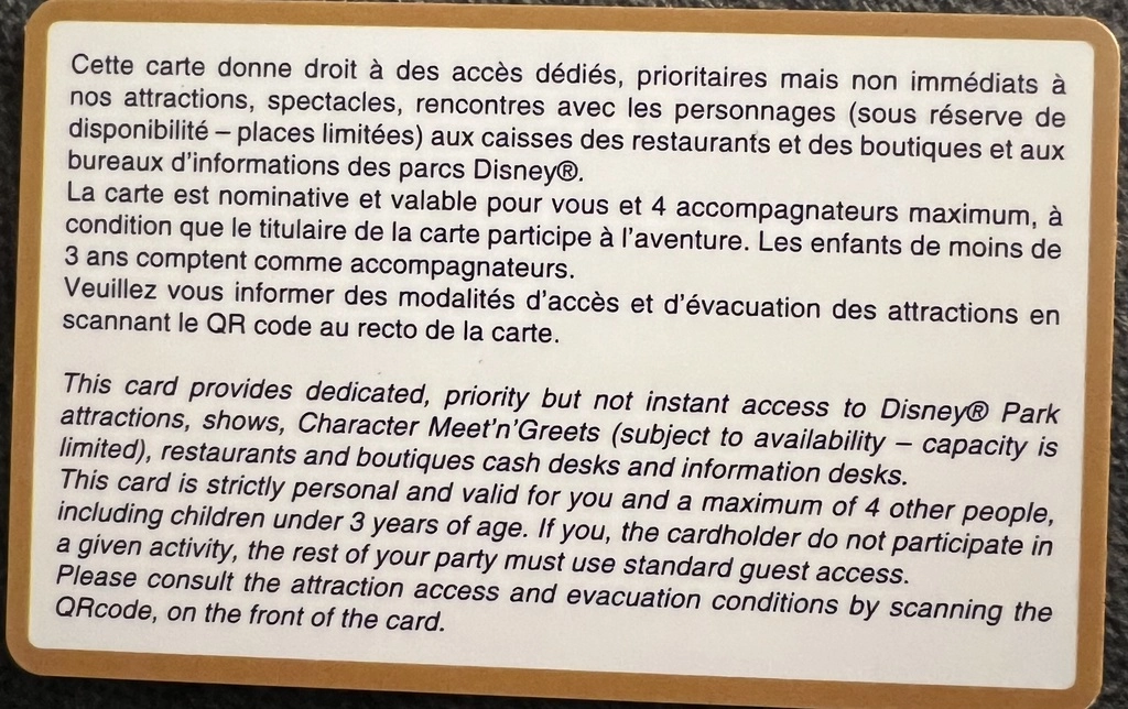 A gold bordered card with text in both English and French. Cette carte donne droit à des accès dédiés, prioritaires mais non immédiats à nos attractions, spectacles, rencontres avec les personnages (sous réserve de disponibilité - places limitées) aux caisses des restaurants et des boutiques et aux bureaux d'informations des parcs Disney®. La carte est nominative et valable pour vous et 4 accompagnateurs maximum, à condition que le titulaire de la carte participe à l'aventure. Les enfants de moins de 3 ans comptent comme accompagnateurs. Veuillez vous informer des modalités d'accès et d'évacuation des attractions en scannant le QR code au recto de la carte. This card provides dedicated, priority but not instant access to Disney@ Park attractions, shows, Character Meet 'n' Greets (subject to availability - capacity is limited), restaurants and boutiques cash desks and information desks. This card is strictly personal and valid for you and a maximum of 4 other people, including children under 3 years of age. If you, the cardholder do not participate in a given activity, the rest of your party must use standard quest access. Please consult the attraction access and evacuation conditions by scanning the QR code, on the front of the card.