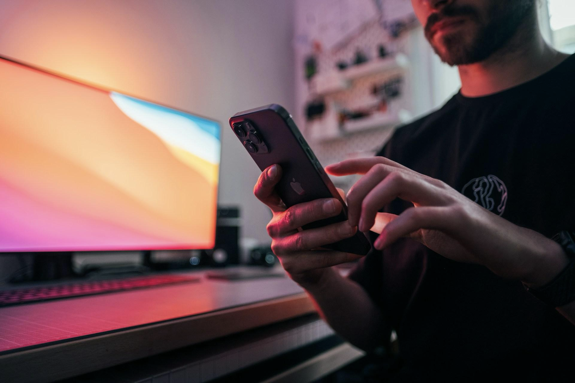 Man in black T-shirt holding phone