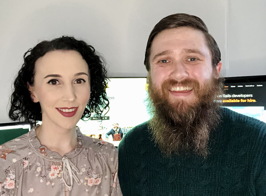 Elaine and Toby sitting in front of two computer monitors, both smiling